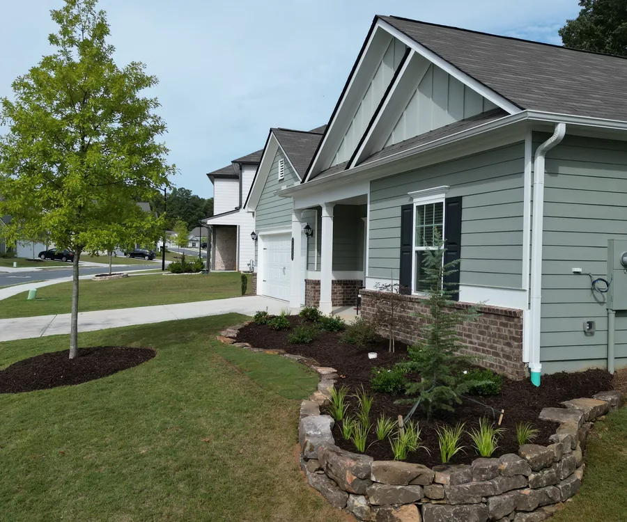 Craftsman-style Acworth home with a stacked-stone garden bed and freshly maintained lawn by KalKare