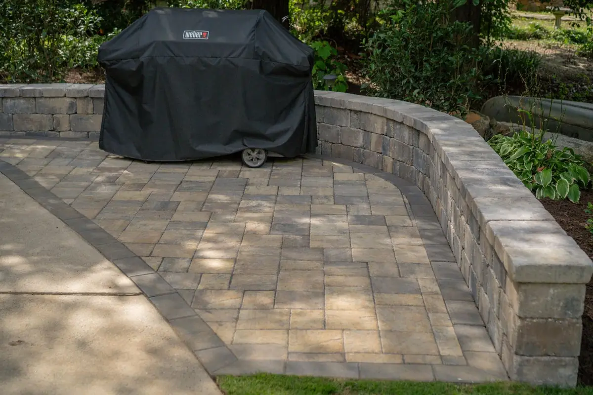 Paver patio wrapped by a curved seating wall.