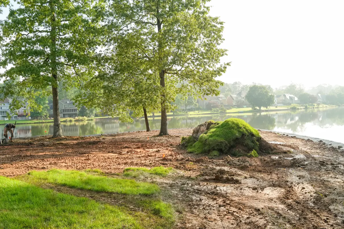 Lakefront yard graded and prepared with bare soil before sod installation