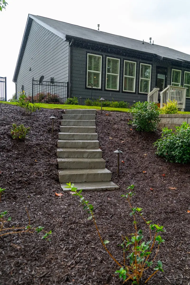 Stone steps climbing a freshly mulched hillside.